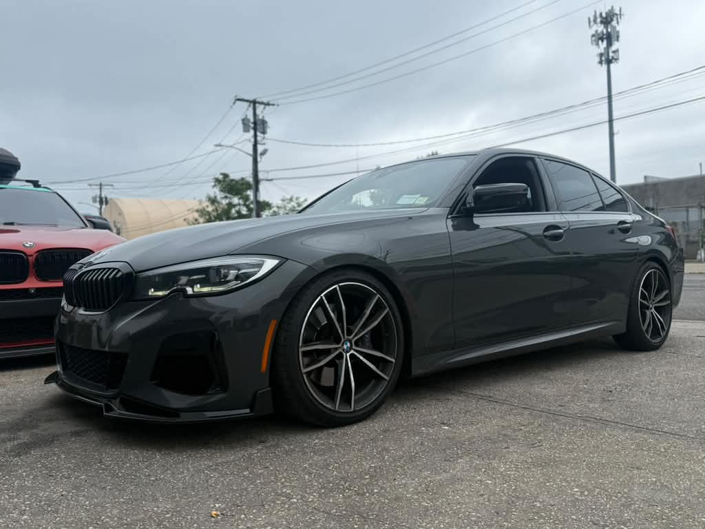 BMW 3-Series: G20 on air, tucked over gloss-black wheels.